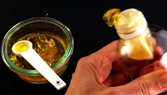 A bowl of gelatin and lung model made from a bottle and a balloon from which gelatin is being pushed out.