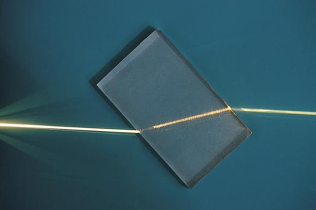 a ray of light refracting as it passes through a glass block