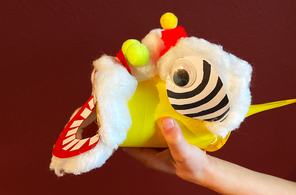 A vortex air cannon made from a plastic container and decorated to look like a Chinese lion