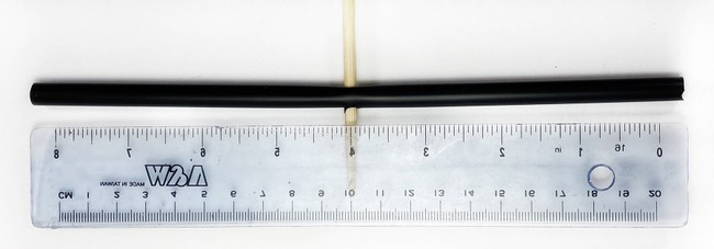 A straw with a ruler next to it. A skewer poked a hole through the straw in the middle.