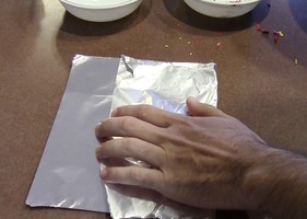 Aluminum foil folded in half over the pile of crayon shavings.