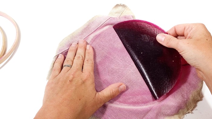 A hand peels the dried alginate mixture from the canvas. 