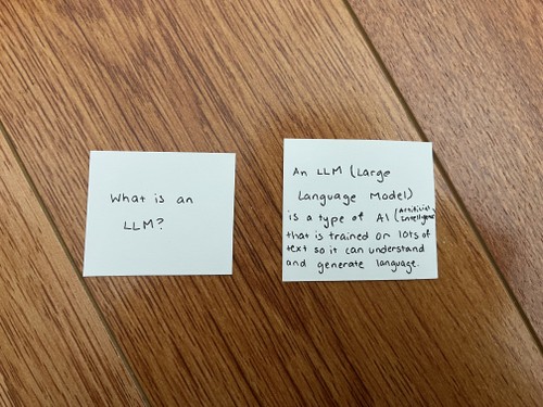 Two small square flashcards. The left card asks, "What is an LLM?" The right card shows the answer: "An LLM (Large Language Model) is a type of AI (Artificial Intelligence) that is trained on lots of texts so it can understand and generate language.