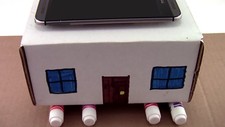 A cardboard house sitting on markers with a cell phone on top for an earthquake lesson plan