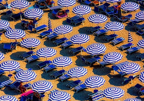 Umbrellas and chairs are lined up in neat rows on the beach