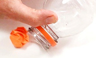 A ball close to a bottle opening.