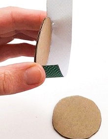 Paper strip being glued along the edge of a circle.