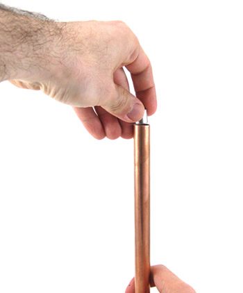 Hand positioning magnet on top of a pipe for magnetic levitating eddy currents experiment