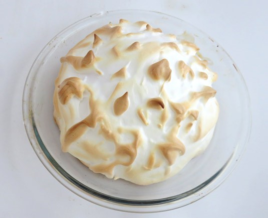 Baked ice cream cake covered in toasted brown meringue