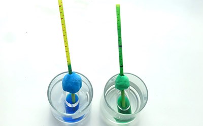 Two thermometers, one placed in an ice-cold water bath and the other placed in a warm water bath.