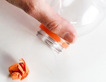 A crumpled-up paper ball place so a blow should easily carry it into a bottle.