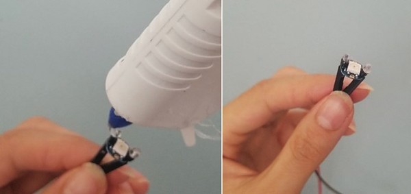 Hot gluing metal leads to secure them onto RGB LED. Hot glued metal leads on RGB LEDs.