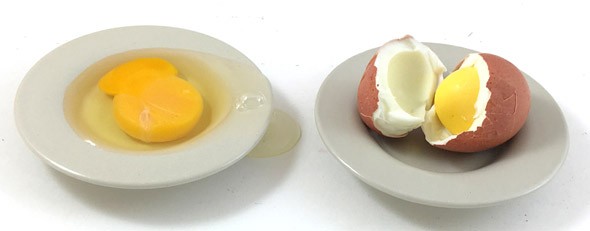 Two small plates one with a raw egg and the other with a cracked open cooked egg.