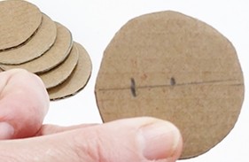 Cardboard circle with the diameter, the center, and a point halfway between the center and the rim marked in pencil.