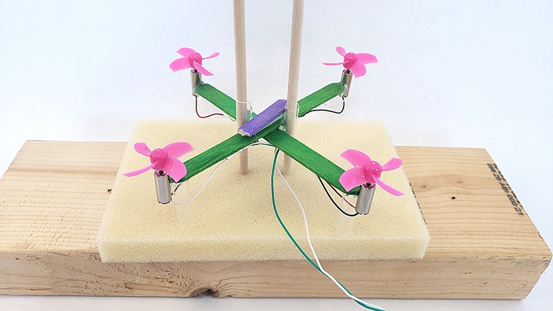Drone with extra popsicle stick piece taped in the middle