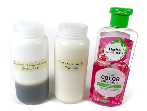 Three bottles of shampoo standing next to each other.