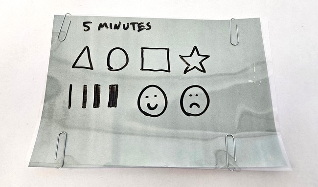 Transparency sheet with shapes drawn on it, attached to sun print paper with paper clips