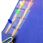 Paper circuit made with LEDs, coin cell battery, paper clip, paper, and copper tape