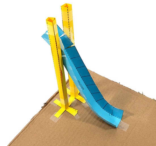 The initial hill of a roller coaster track built from paper