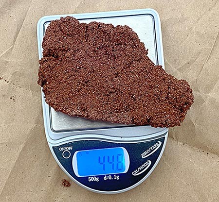 A large piece of regolith brick being weighed.