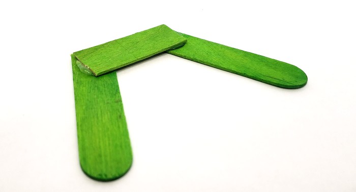 A base for the robot with two 'feet' made from popsicle sticks.