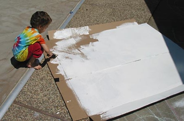 Apply layer of gesso onto the cardboard while making the solar heater