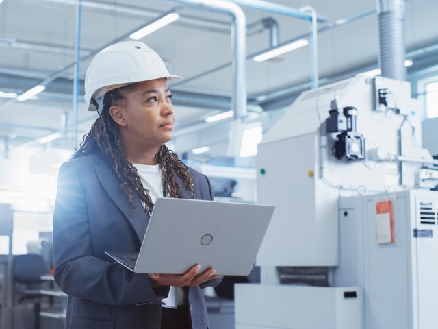 female engineer in hard hat with laptop