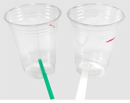 Straws are inserted into holes cut near the bottom of two plastic cups