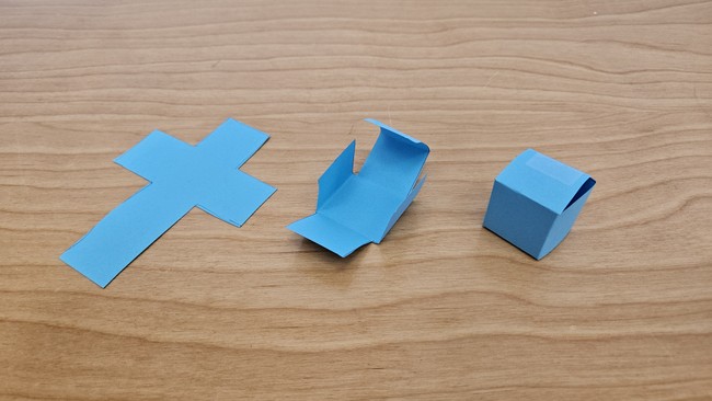 a small cube folded from a piece of paper and held in place with tape