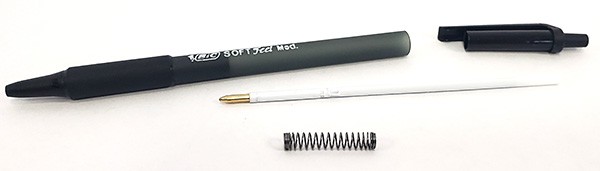 A disassembled retractable pen, revealing the spring inside