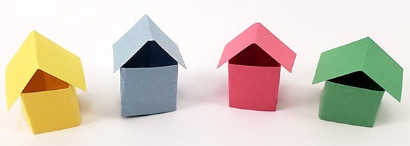  four small houses made from construction paper 