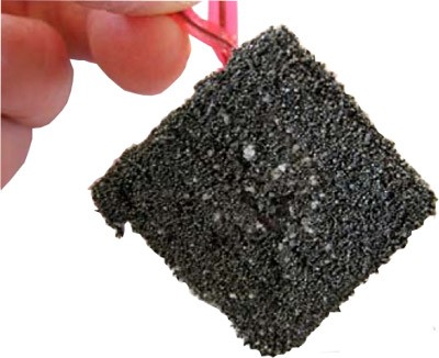 A square of magnetic tape covered in iron filings and salt