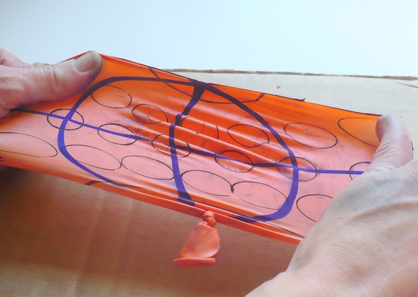 wo hands stretching out the cut open balloon.
Circles away from the equator are larger than those on the equator.