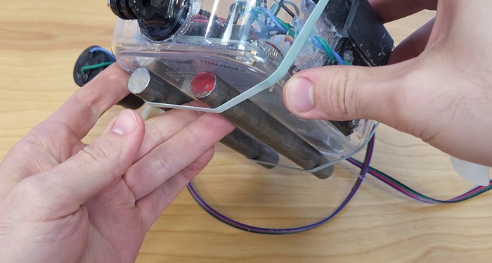 Two steel rods attached to the underside of the plastic ROV container with rubber bands