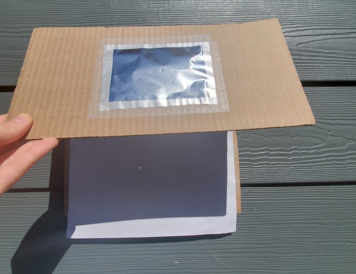 A pinhole projector being used outdoors.