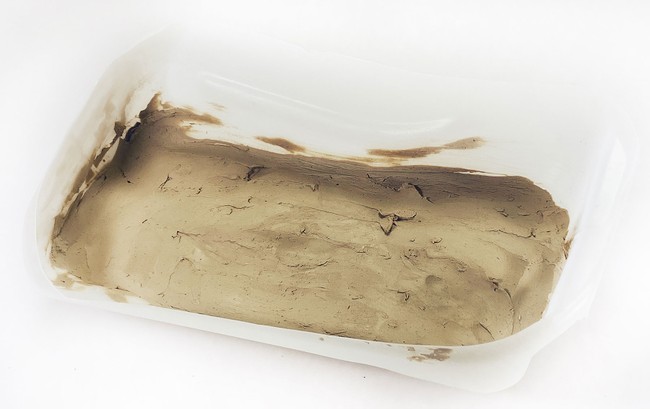 Cut-open gallon jug filled with a layer of clay, to represent pavement