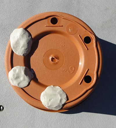 Drainage holes of a flower pot covered with putty