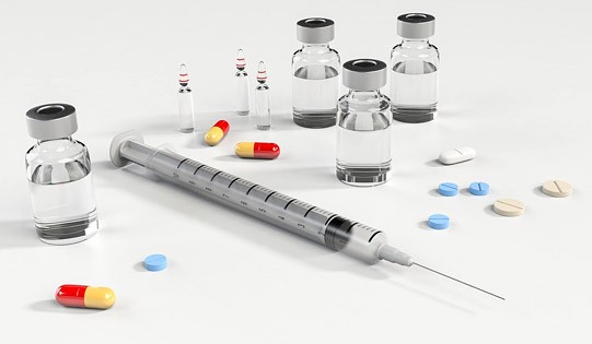 Different forms of medications, such as vials with liquid, pills, and tablets.