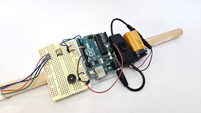 The Arduino and breadboard mounted to the stick with tape on the underside