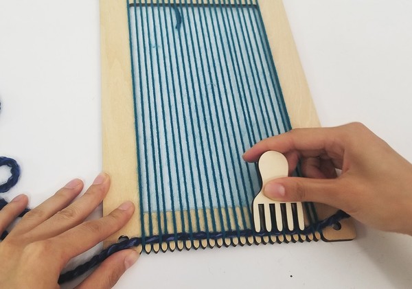 Combing the row of woven yarn. 