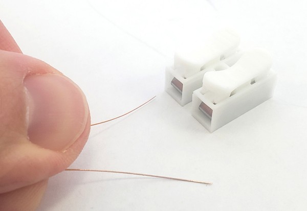 Preparing magnet wire to insert into spring clips