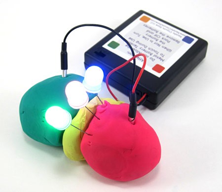 Play-Doh balls connected to a battery pack and separated by insulating clay power three LEDs