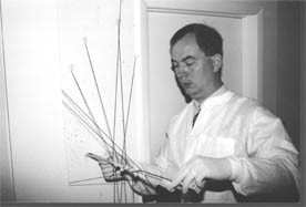 Photo in black and white of a forensic scientist examining blood spatter in a room