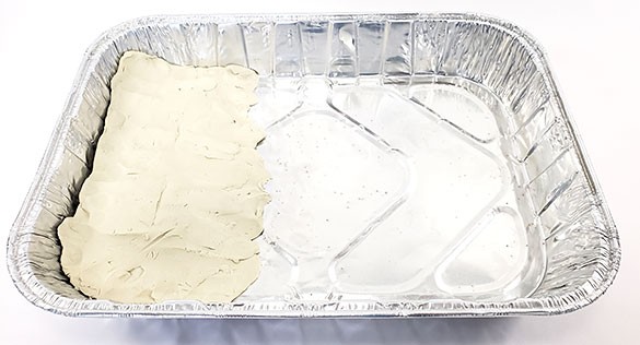  baking tray with sloped beach formed from modeling clay on one end 