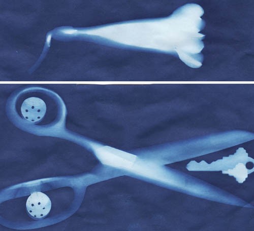 White images of a flower, scissors, buttons and a key imprinted on blue paper