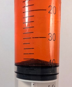 Syringe measuring 40 mL of red liquid.