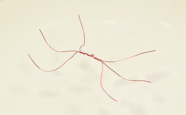 Three copper wires twisted together at the center form a bug with six legs