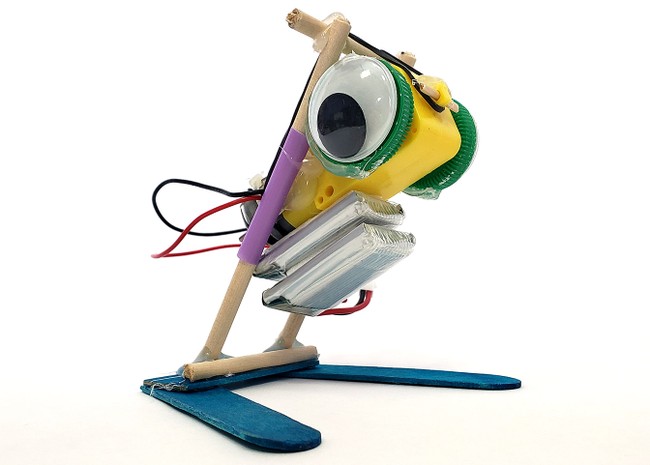 A jumping robot made from popsicle sticks, wooden dowels, straws, and rubber bands.