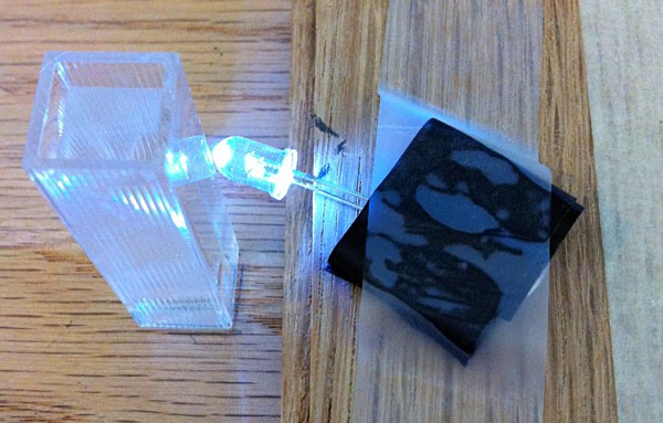 Lit LED bulb shining through the clear water curvette at a slightly different angle to avoid overexposure in images