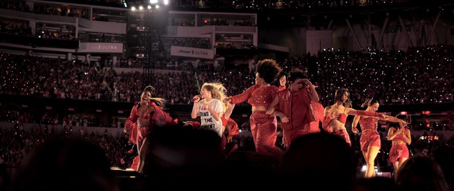Taylor Swift and her backup dancers performing onstage during an Eras Tour concert